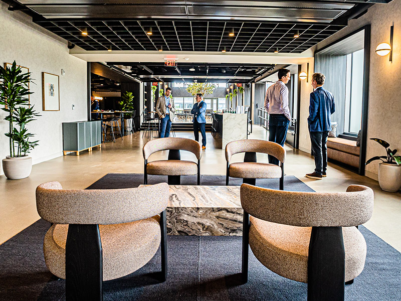 Lounge with high ceilings, tree planter, and modern seating at 40 Thorndike's amenity space
