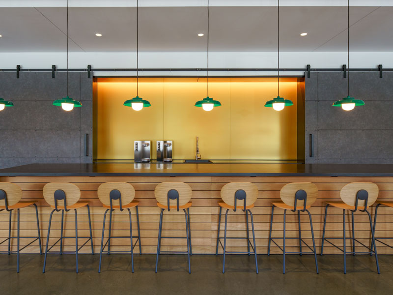Contemporary conference center bar with wood accents and green pendant lights for a modern touch