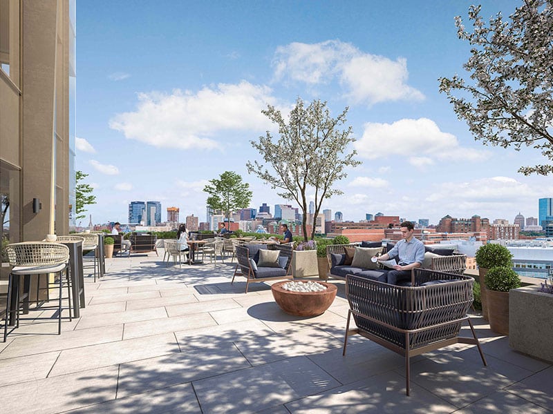Rooftop terrace featuring stylish seating, planters, and panoramic views of the Boston skyline