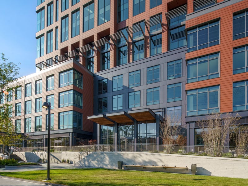 Modern plaza entrance to the 40 Thorndike building, surrounded by green spaces and seating areas