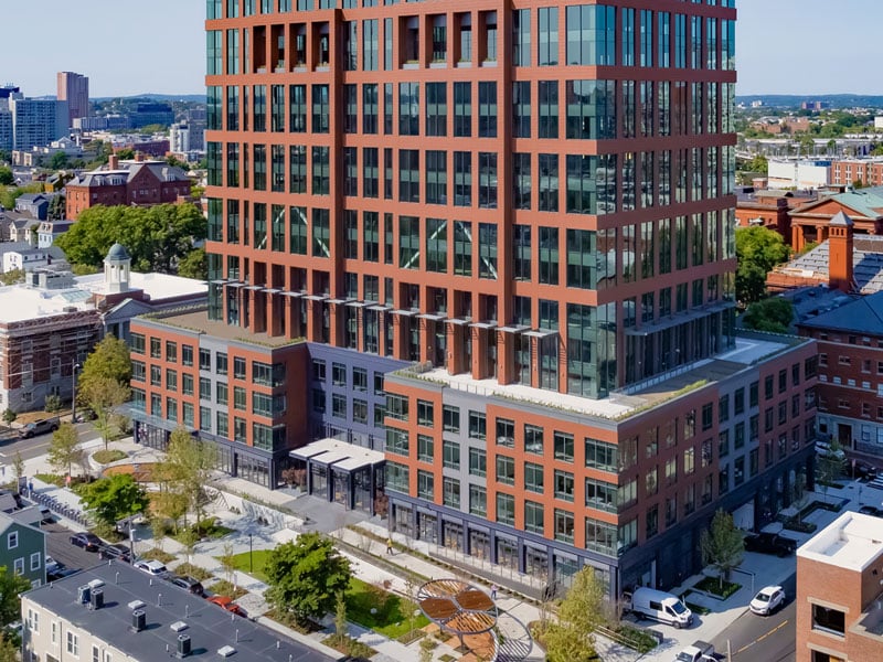 Spring Street perspective of 40 Thorndike, showcasing its towering architecture and connected plaza