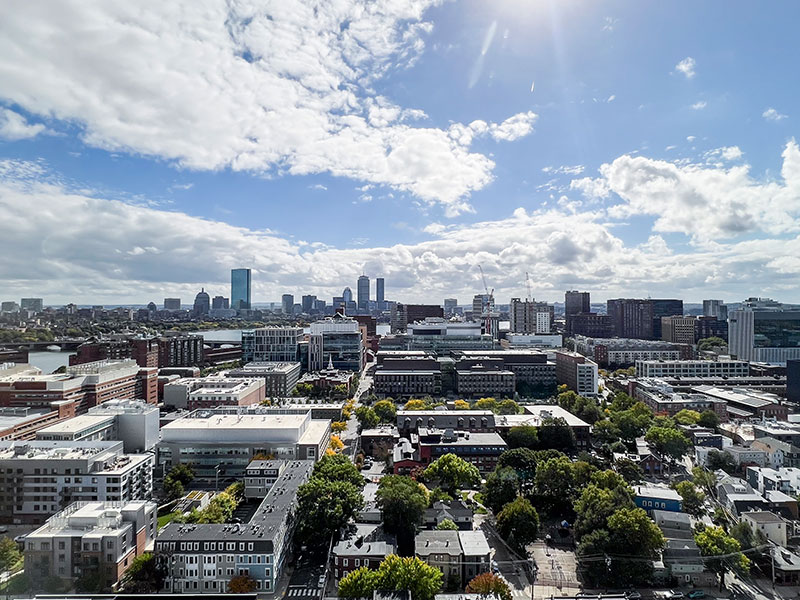 Panoramic view of Cambridge, highlighting urban buildings and the bright blue sky with scattered clouds