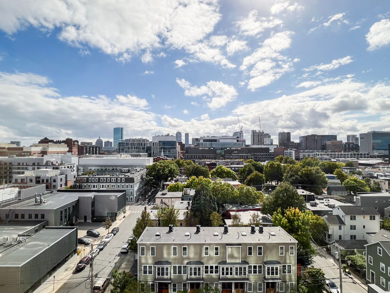 Southward view of Cambridge rooftops with modern office buildings and distant construction cranes